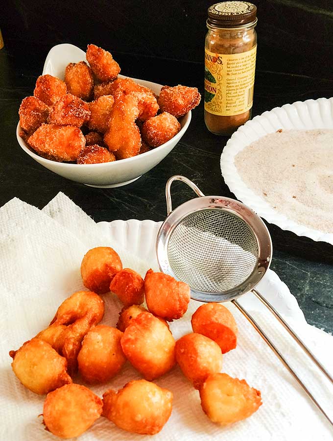 fried churros bites about to be rolled in cinnamon sugar