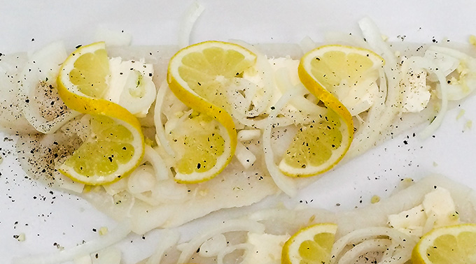 Preparing fish with lemon and onion for oven baked cod recipe