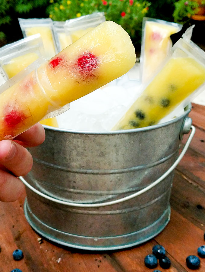 Pail full of mango berry popsicles, a fresh flavorful treat for a hot day