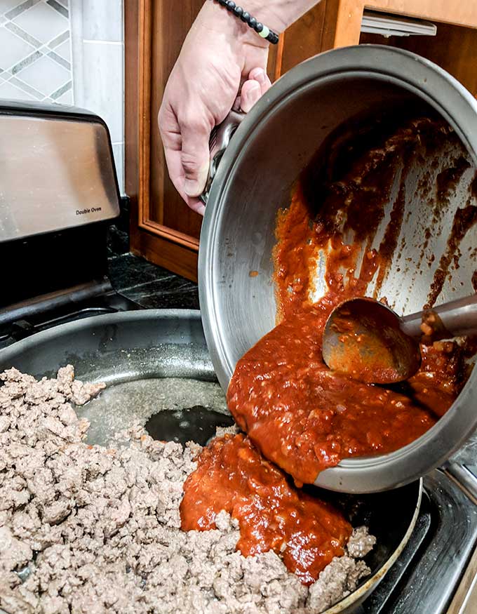 pouring enchilada sauce over beef