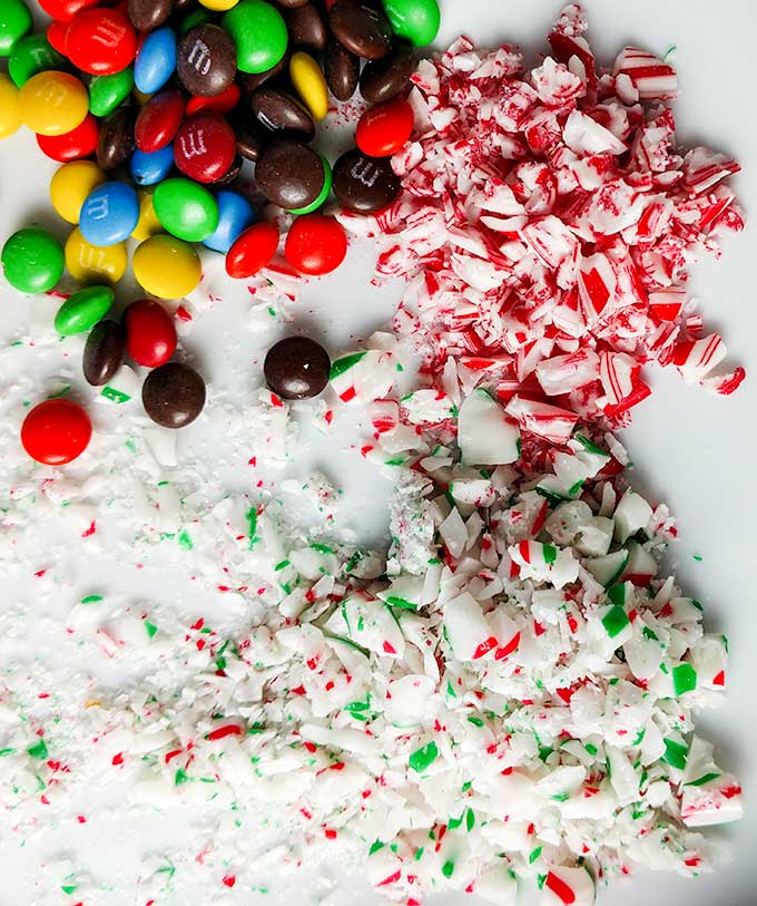 Candy canes M&Ms and other toppings for chocolate dipped Oreo Christmas cookies. OnTheGoBites.Com