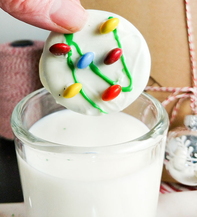 Chocolate coated Oreos with string of Christmas lights out of m&ms. OnTheGoBites.Com