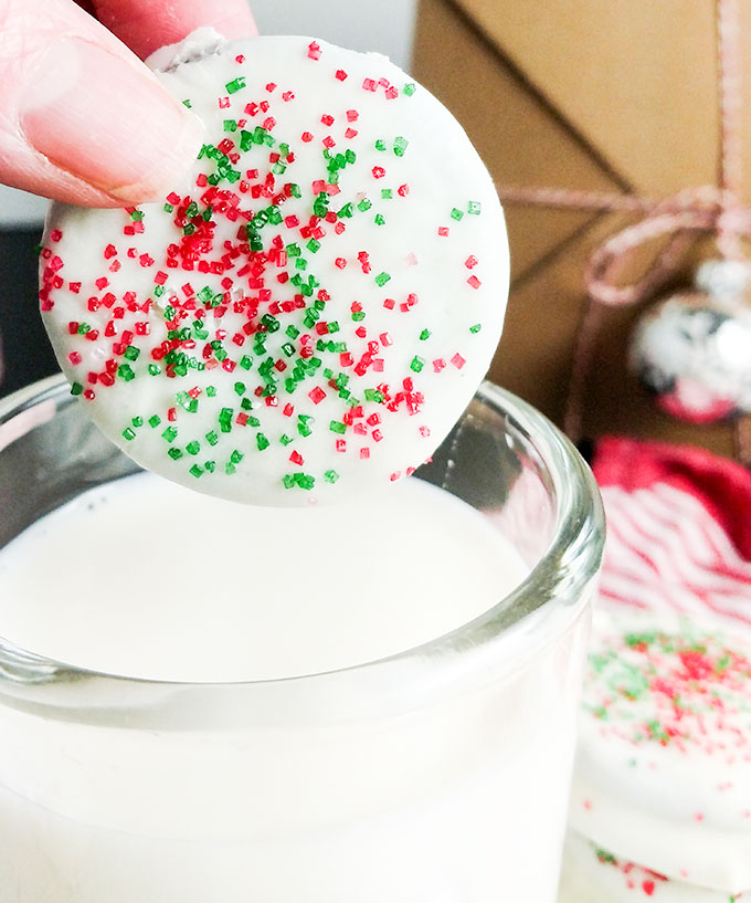 Chocolate dipped Oreo cookie with sprinkles dipping in milk