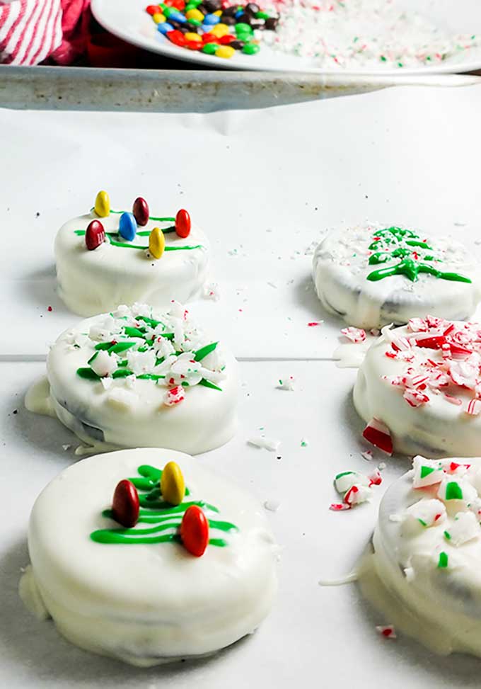 Chocolate dipped Oreo Christmas cookies on parchment lined tray. OnTheGoBites.Com