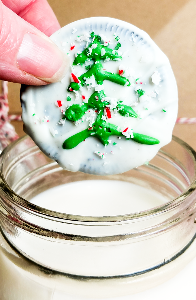 Chocloate dipped Oreo with traditional tree decoration and candy cane snow. OnTheGoBites.Com