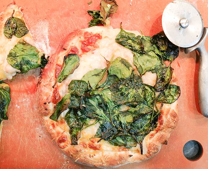 spinach and white bean pizza on cutting board