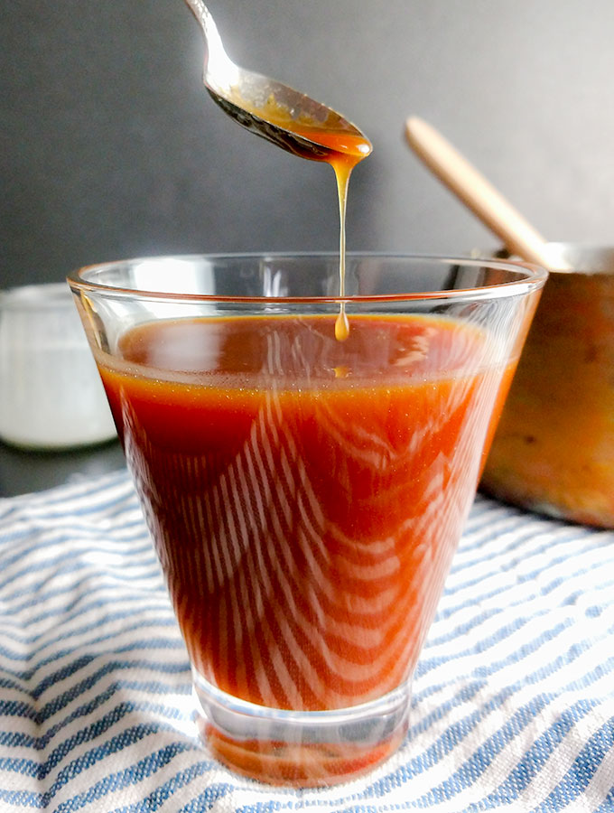 caramel sauce dripping off spoon into glass