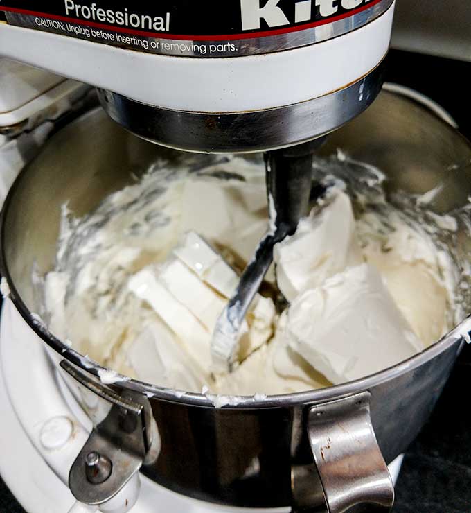 mixing cream cheese in mixer for turtle cheesecake