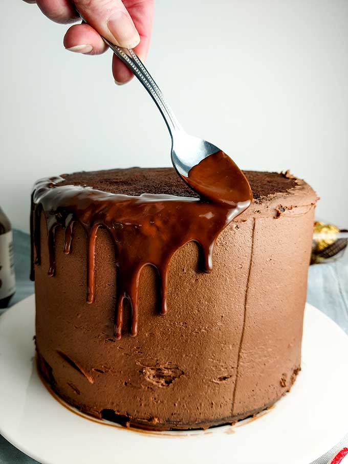 applying chocolat ganache over nutella buttercream frosting