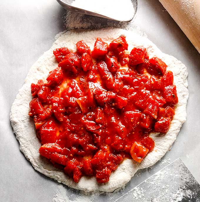 sausage pizza with simple tomato sauce on raw dough