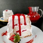 slice of angel food cake with strawberries and strawberry sauce