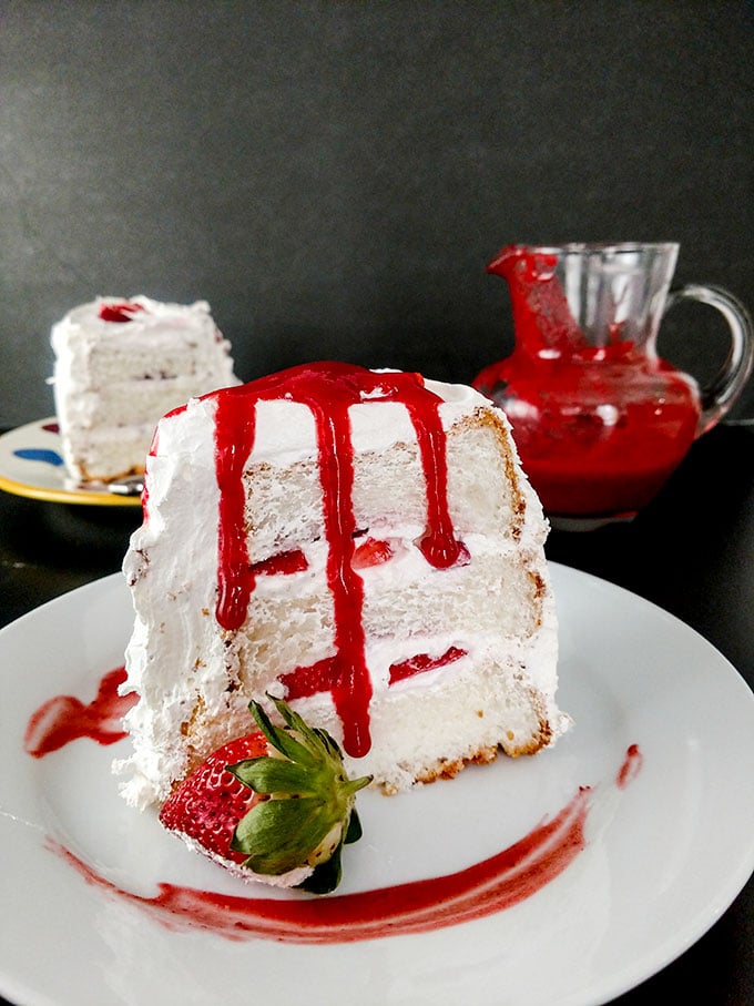 slice of angel food cake with strawberries and strawberry sauce