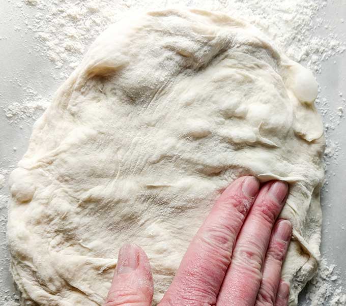 shaping pizza dough with your fingers