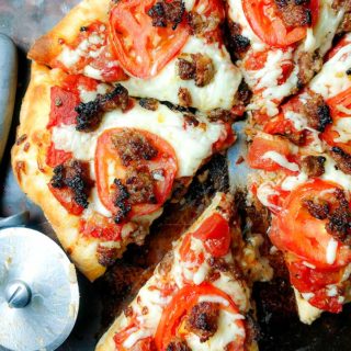 sausage pizza with simple tomato sauce on pizza stone