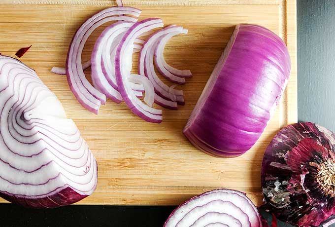 slicing red onion into half moons