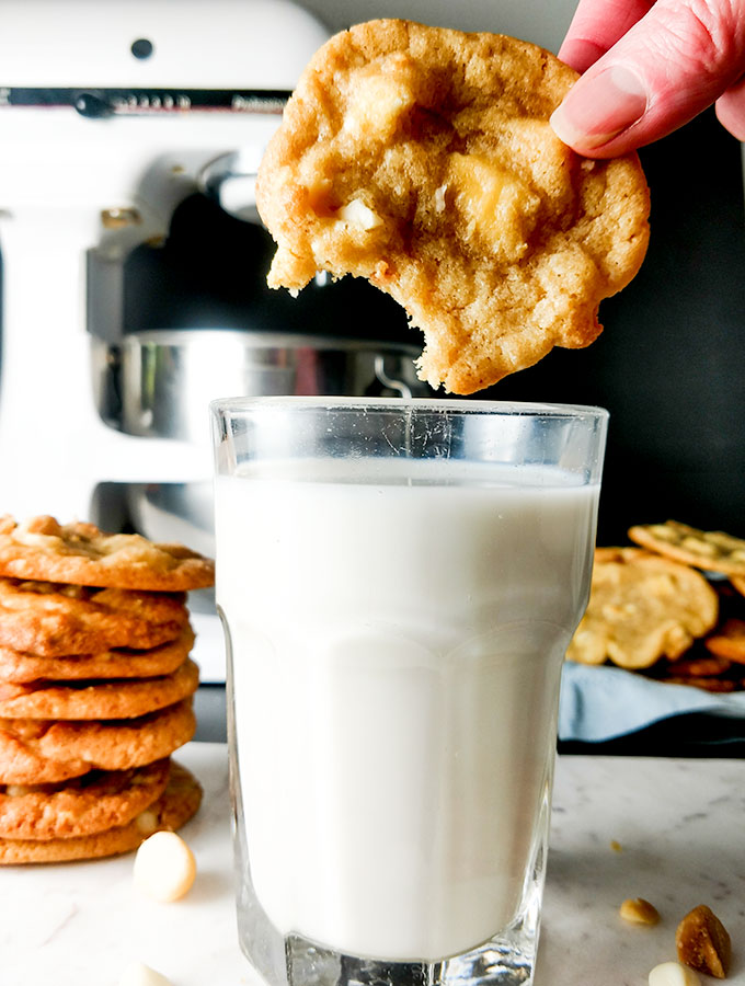dunking white chocoloate macadamia nut cookie in milk