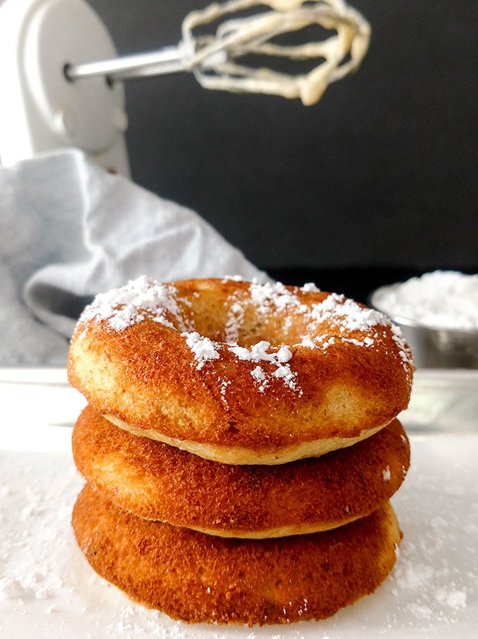 banana bread donuts stacked with powdered sugar