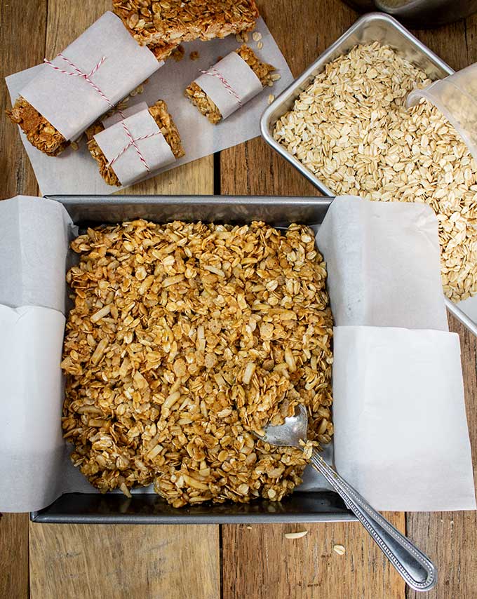 pressing granola in pan for homemade peanut butter granola bar recipe