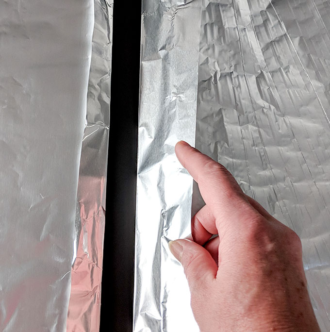 Lining a rimmed baking tray with foil for oven baked bacon