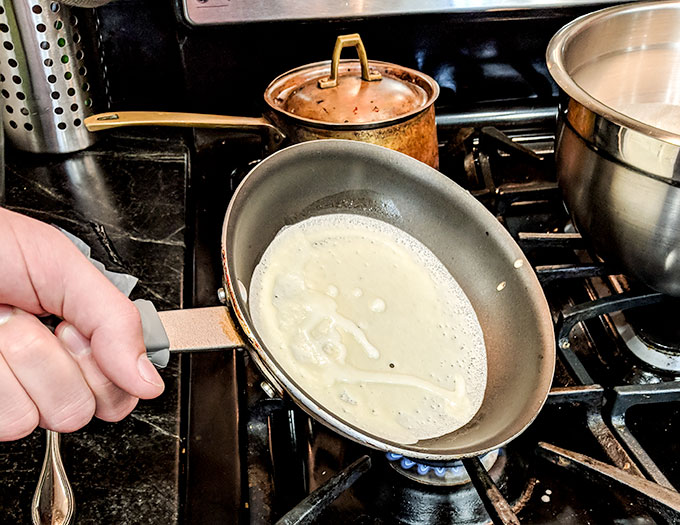 swirling crepe batter in pan