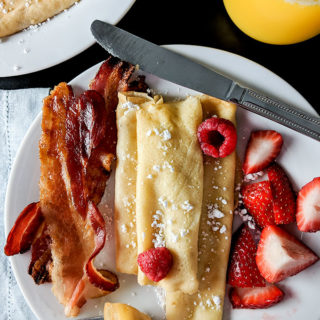 breakfast crepes with berries and powdered sugar