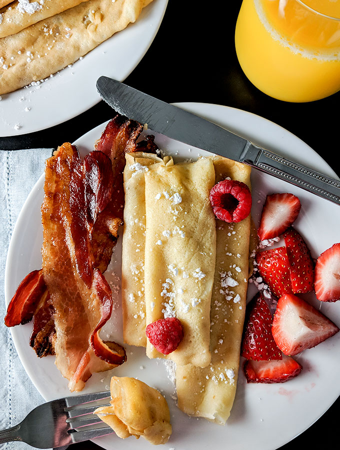 breakfast crepes with berries and powdered sugar