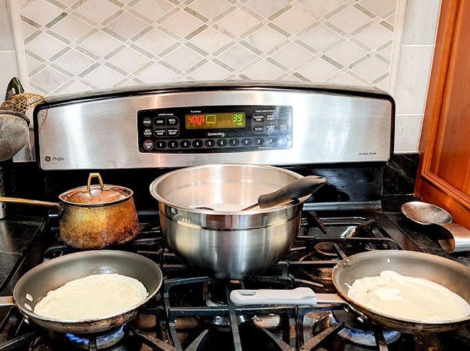 cooking multiple pans of breakfast crepes