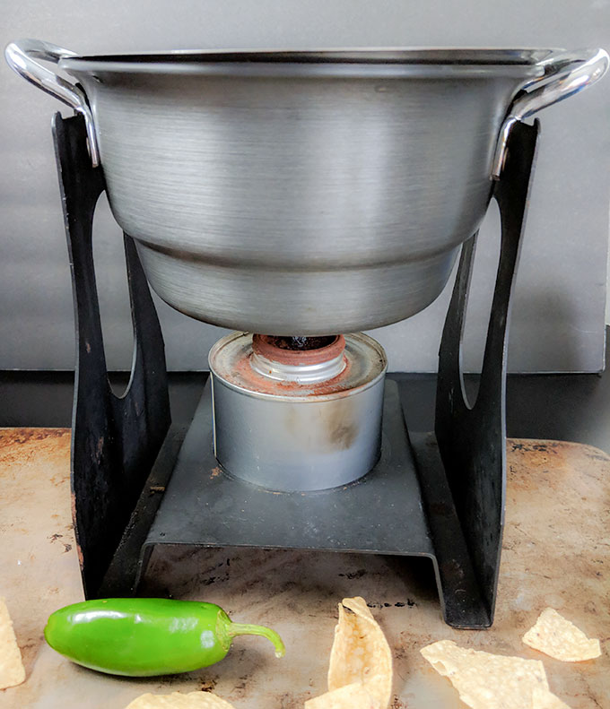Mexican cheese dip kept warm in fondue pot
