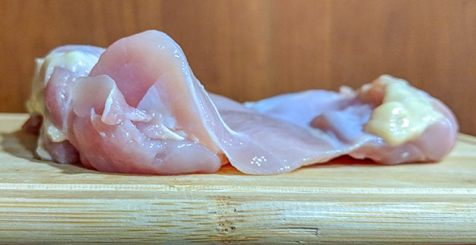 Raw chicken thigh unrolled with thicker end