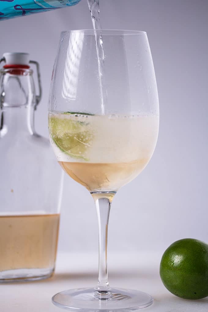 mixing seltzer water with simple syrup for homemade ginger ale recipe