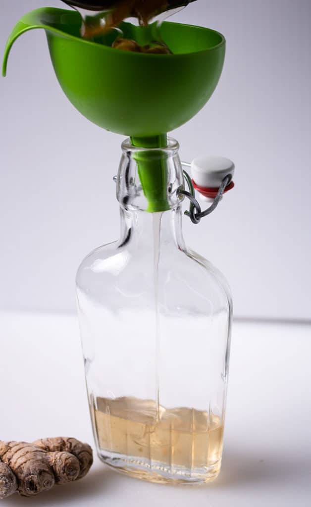 use funnel to pour simple syrup into bottle